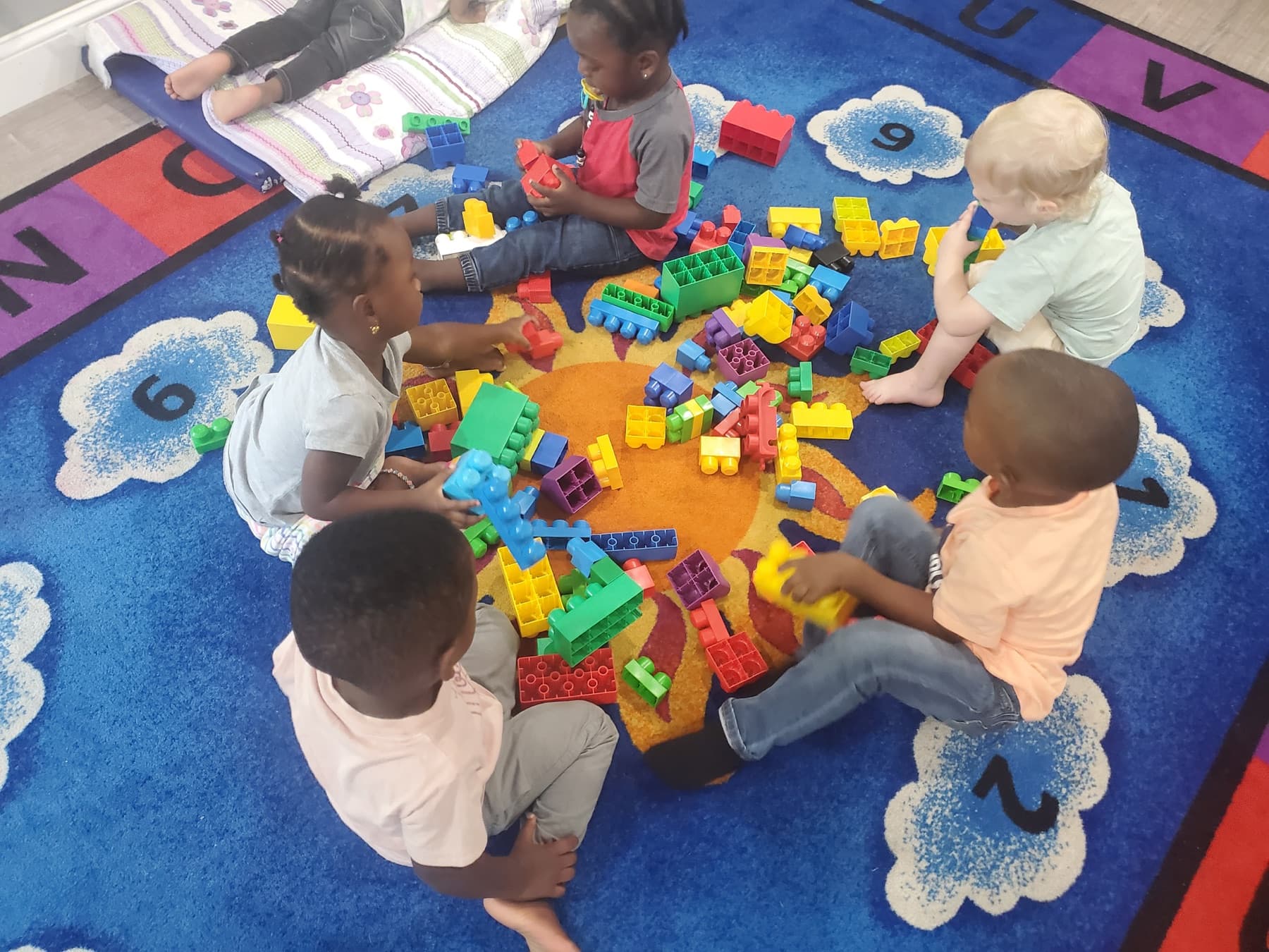 Children building with colorful blocks on a classroom rug