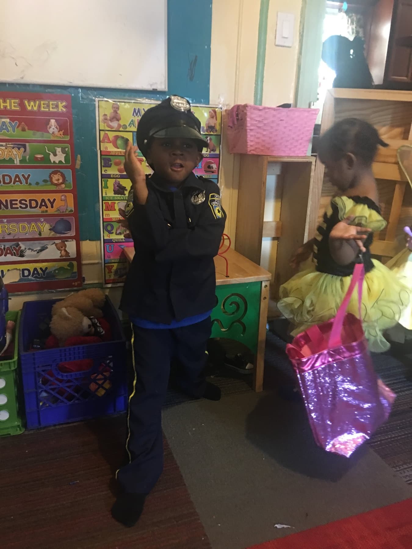 Children in dress-up costumes near classroom learning materials