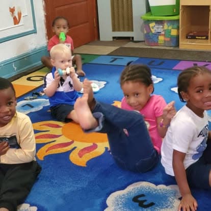Children seated together on a classroom rug